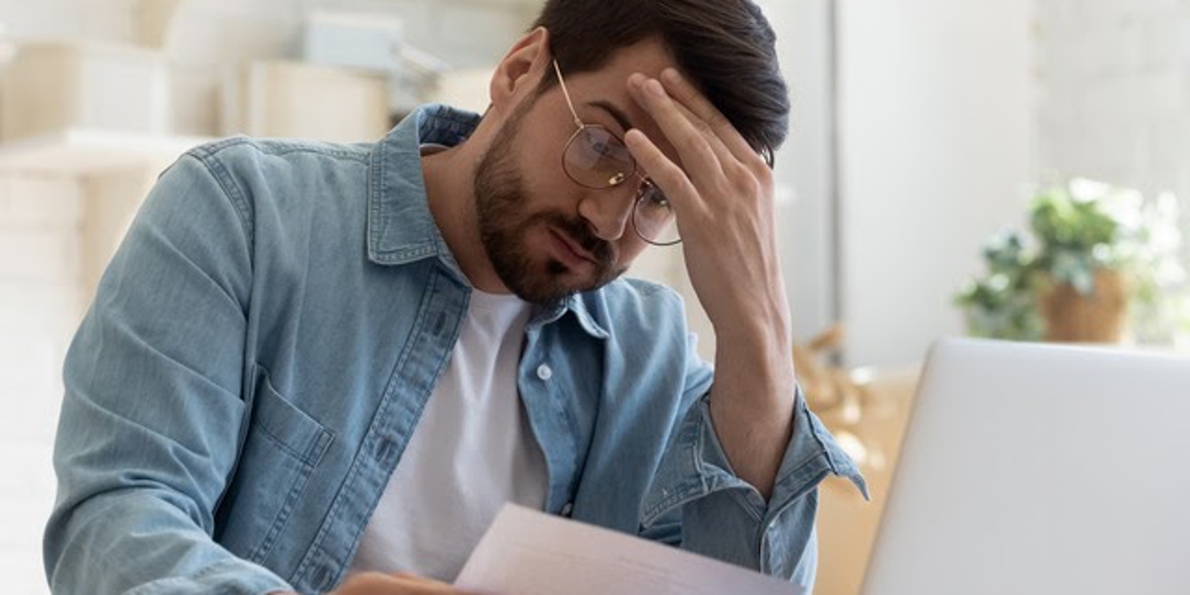 man looking at piece of paper, stressed out