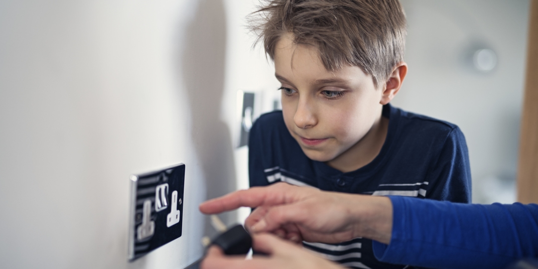 child looking at electrical outlet