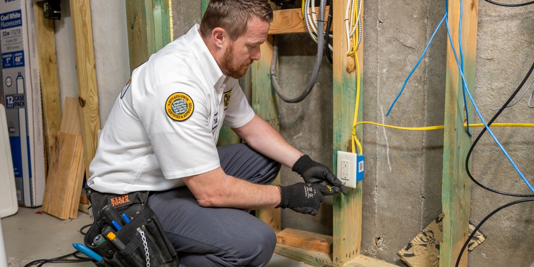 tech adjusting power outlet in attic