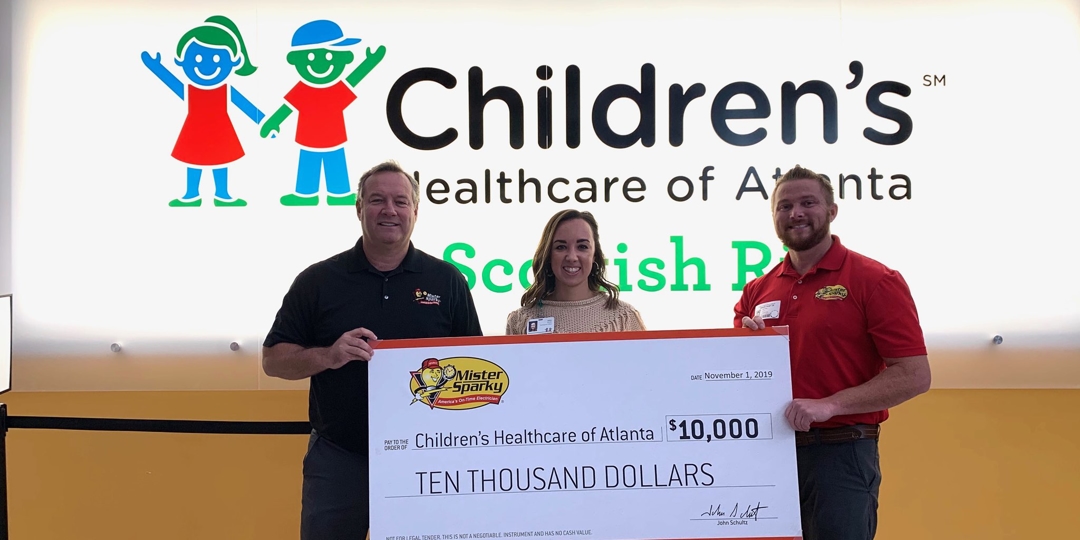 Mister Sparky of Atlanta staff holding a check for ten thousand dollars for Children's healthcare of Atlanta