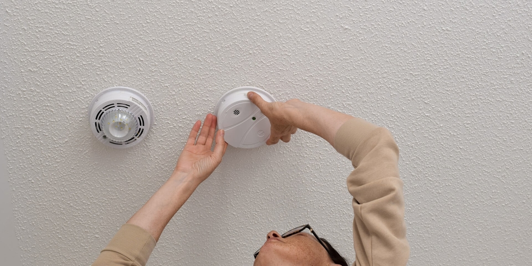 Person checking a smoke detector