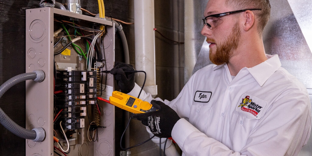 A photo of an electrician working on a panel