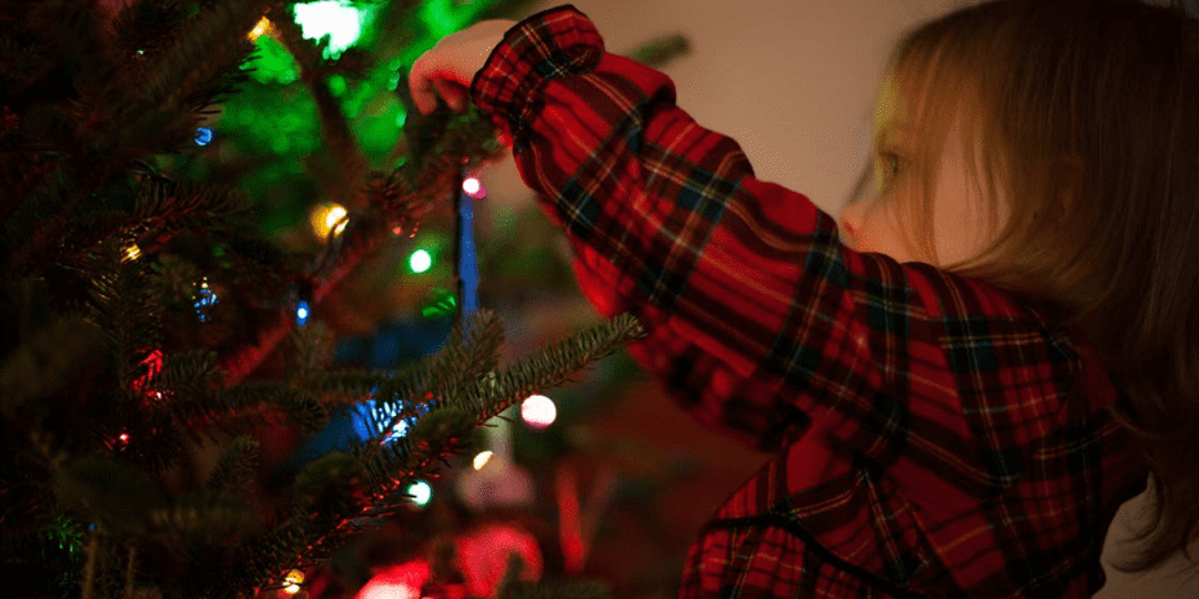 a child decorating a Christmas tree