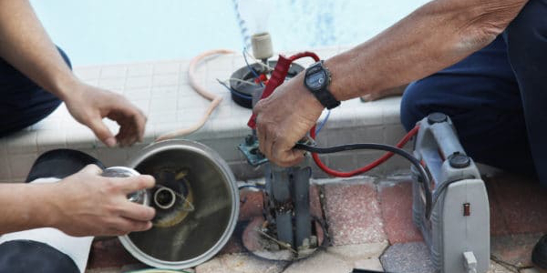 men working on electrical wires near the pool