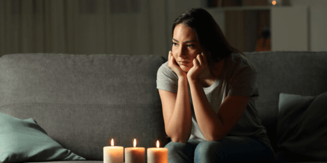 A lady using candle light during a power outage